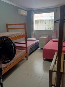 um quarto com dois beliches e uma janela em hostel praia dos ingleses em Florianópolis