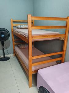 2 beliches de madeira num quarto com uma ventoinha em hostel praia dos ingleses em Florianópolis mais 5 fotografias