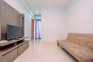 Una televisión o centro de entretenimiento en Combined 2BR with Study Room Titanium Square Apartment By Travelio