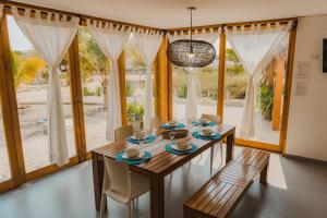 a dining room with a table and chairs and windows at Beach Home Organos Piura Family Vacations in Los Órganos +11 photos