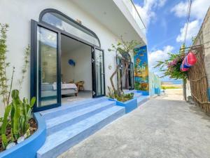 a house with blue steps leading to a glass door at Dứa Homestay in Cu Lao Thu