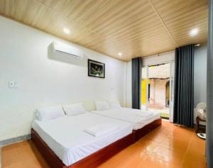 a bedroom with a large white bed in a room at Newlife Homestay in Dong Hoi