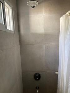 baño con ducha, aseo y ventana en Casa Las Dunas- 6 cuadras del mar, en Monte Hermoso