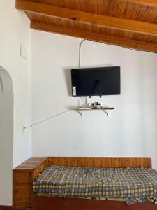 TV de pantalla plana colgada en una pared con cama en Casa Las Dunas- 6 cuadras del mar, en Monte Hermoso 7 fotos más