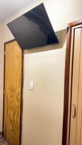 a room with a door and a television on the wall at Casa House - Ilha Grande Vila Do Abraão in Angra dos Reis