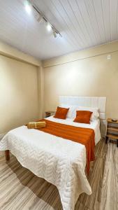 a bedroom with two beds with orange and white sheets at Casa House - Ilha Grande Vila Do Abraão in Angra dos Reis