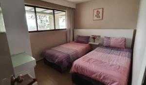 a bedroom with two beds and a window at Seaview Regency Tanjung Tuan Apartment A7-4 in Pulau Burung