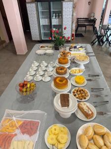 a long table with plates of food on it at Pousada Canavieiras Frederic in Canavieiras