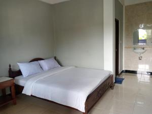 a bedroom with a large white bed in a room at ESTEVANIA LODGE Kelimutu in Ende