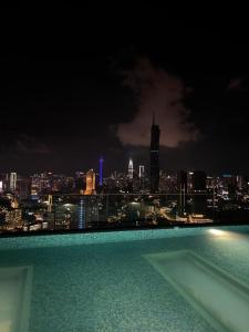 a view of a city skyline at night with a swimming pool at Riveria City near KL Sentral with 118 view Sky Infinity Pool by COBNB in Kuala Lumpur