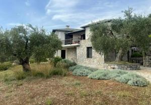 una casa de piedra con árboles delante de ella en Villa Irene, en Chorto