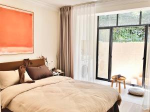 上海市にある禅茶庭院两居室2-Bedroom Apart ment With Gardenのベッドと大きな窓のある寝室