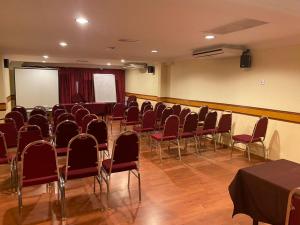 a conference room with chairs and a whiteboard in it at Flora Place Hotel in Kota Bharu