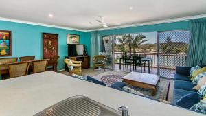 a living room with a couch and a table and a balcony at Sunrise Cove Holiday Apartments by Kingscliff Accommodation in Kingscliff