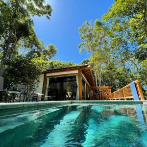 a swimming pool in front of a house at CASA PREGUIÇA - TRANCOSO - ECO in Trancoso