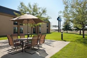 uma mesa e cadeiras com um guarda-sol em frente a um edifício em Days Inn by Wyndham Fargo em Fargo