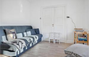 a living room with a blue couch and a chair at 3 Bedroom Gorgeous Home In Gudhjem in Gudhjem
