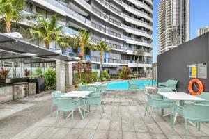 an outdoor patio with tables and chairs and a pool at MEGA VIEWS at Oracle - level 32 in Gold Coast