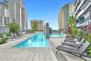 a swimming pool with lounge chairs and buildings at MEGA VIEWS at Oracle - level 32 in Gold Coast