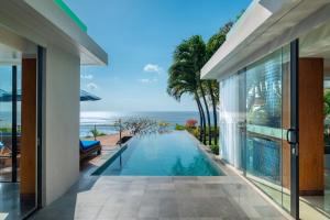 an infinity pool in a villa with the ocean in the background at Anantara Uluwatu Bali Resort in Uluwatu