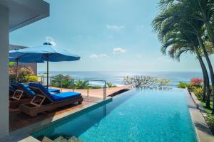 a swimming pool with a view of the ocean at Anantara Uluwatu Bali Resort in Uluwatu
