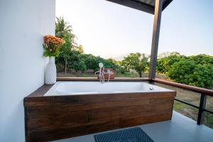 a large bath tub in a room with a window at The Farmer Farm Stay & Cafe in Chom Thong