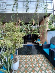 una hall con piante e sedie in un edificio di MADOR Malang Dorm Hostel a Malang