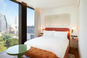 a hotel room with a bed and a large window at The Standard, Bangkok Mahanakhon in Bangkok