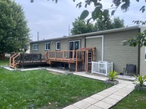 a mobile home with a deck and a porch at Stephna555 in Saint-Pascal