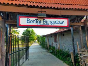 un cartello per un edificio con un cartello per trombe bonkat di Bontai Riverside Cottages & Long-Stay Residences a Don Det