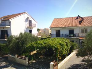 a view of two houses and a yard with trees at Apartments Samodol in Vodice