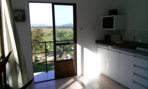 a kitchen with a door to a balcony with a view at Morada Colibri in Gamboa