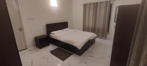 1 dormitorio con 1 cama y altavoz en el suelo en Bougainville Rooms, en Sāhāpur