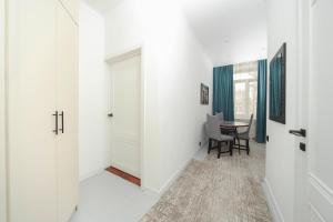 a hallway with white walls and a table with chairs at Люкс Крупская 78 in Pavlodar