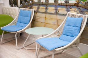 two wicker chairs and a table on a balcony at Hotel Planernaya in Domodedovo