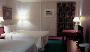 um quarto de hotel com duas camas e uma janela em Blue Bird Hotel em Melfort