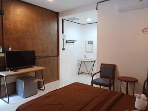 a bedroom with a bed and a desk and a television at Khlong Thom Resort in Khlong Thom