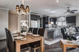 a kitchen and dining room with a wooden table and chairs at Leogate Estate Villas in Pokolbin