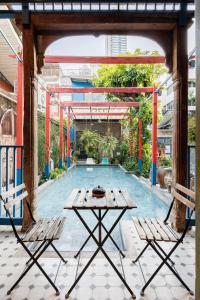 ein Tisch und zwei Stühle vor einem Pool in der Unterkunft The Anonymous House in Bangkok