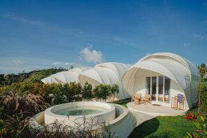 a group of domed buildings with a hot tub at Onion Hill Glamping by Manara in Kintamani
