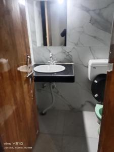 a bathroom with a sink and a mirror at Yoga homestay in Khajurāho