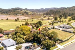 an aerial view of a village with trees and a road at Surf and Stay in Tairua