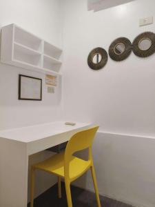 a yellow chair sitting at a desk with a white table at Casa Bahia Dive Resort in Bagalañgit
