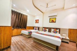 a bedroom with two beds and a window at FabExpress Shri Sai DX - Nr Adarsh Nagar Metro in New Delhi