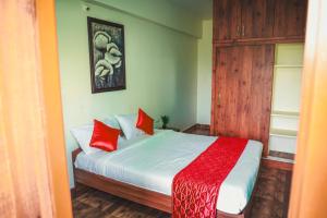 a bedroom with a bed with red pillows on it at Shree Varahi HomeStay in Tirupati