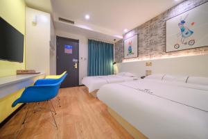 a bedroom with a large white bed and a blue chair at QiQiaoWu Fashion Hotel - Beijing Songjiazhuang Subway Station in Beijing