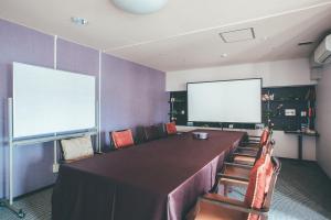 a conference room with a large table and a screen at Kakegawa Grand Hotel in Kakegawa