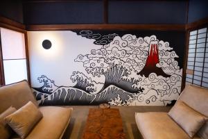 a room with a wall with a painting of a wave at NATAN - 7mins walk from Kawaguchiko Station in Fujikawaguchiko