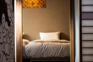 a bedroom with a bed with a white pillow at NATAN - 7mins walk from Kawaguchiko Station in Fujikawaguchiko