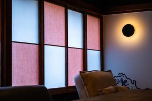a dog sitting in a chair in front of a window at NATAN - 7mins walk from Kawaguchiko Station in Fujikawaguchiko